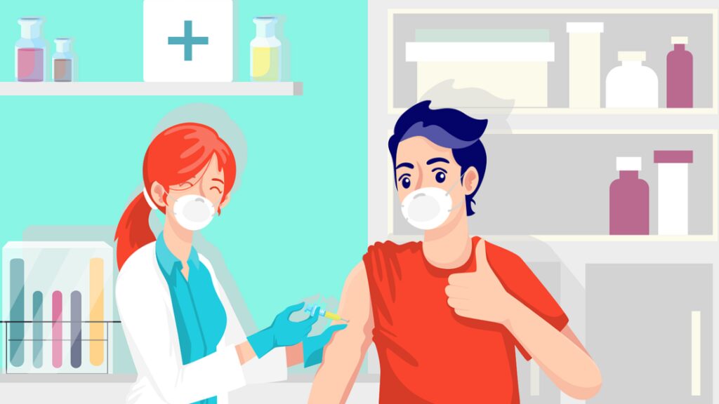 Impfung (Symbolbild): Rothaarige Ärztin impft jungen Mann mit rotem T-Shirt, der den Daumen nach oben macht